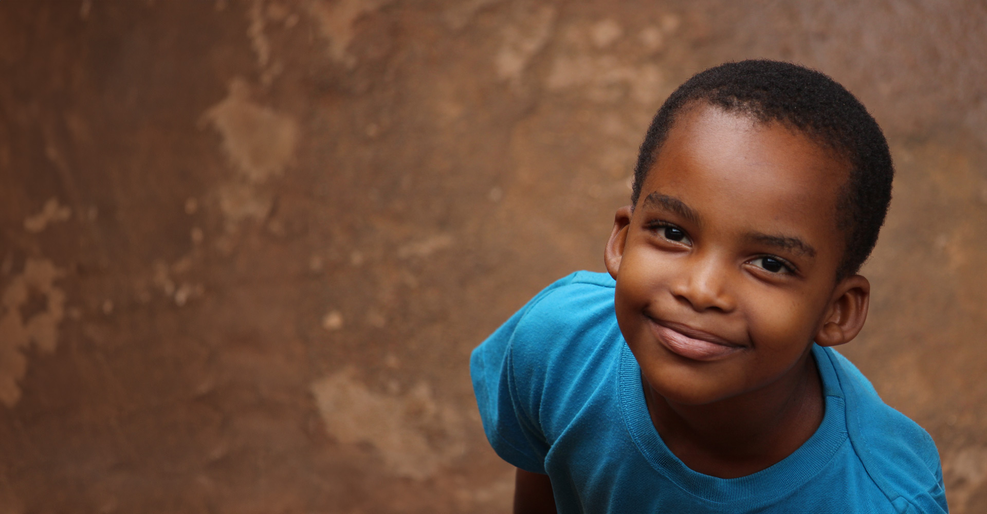 Porträt eines Jungen aus Uganda - das Bildungsprojekt von Helfende Hände schenkt Kindern Selbstvertrauen, Perspektiven und eine Chance auf ein besseres Leben.