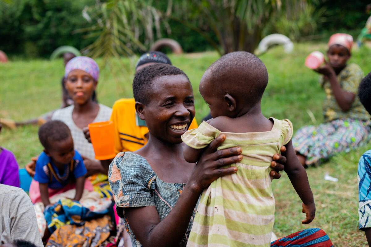 Burundi Hilfsprojekt: Lächelnde Mutter mit Kind nach Nahrungsmittelhilfe – Spenden unterstützen Familien in Not und fördern Perspektiven für die Zukunft.