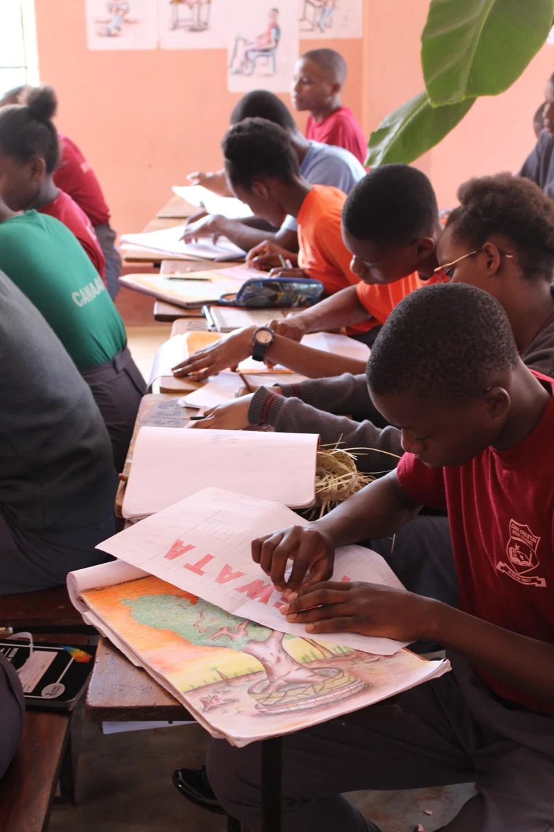 Schülerinnen und Schüler in Uganda arbeiten konzentriert an ihren Aufgaben im Klassenzimmer der Zana School. Das Schulprojekt stärkt Bildung und Zukunftsperspektiven.